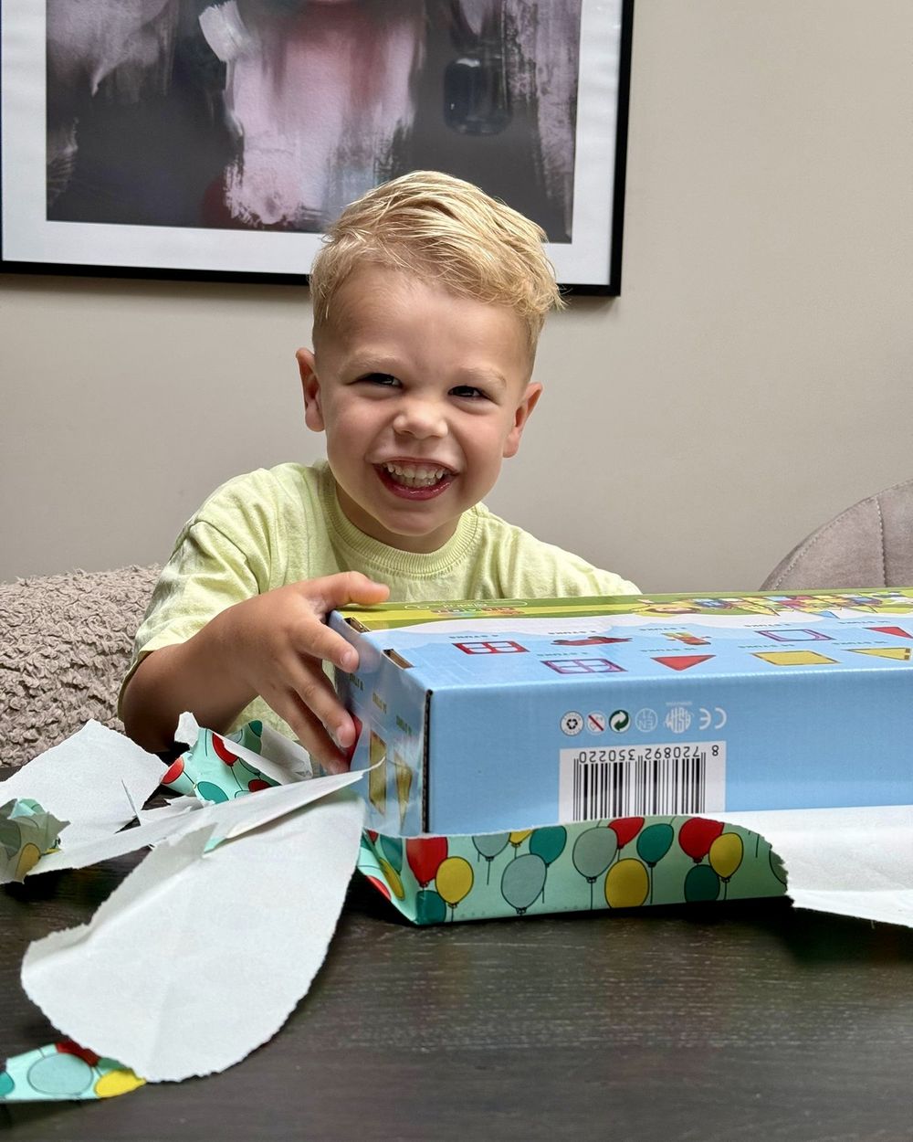 Jongen pakt lachend een doos Gladi Tiles uit